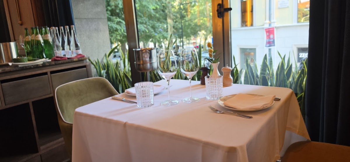 Set table by tall windows overlooking the boulevard